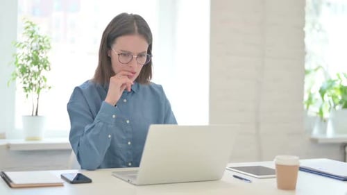 Young Adult Woman Working on Laptop in Office