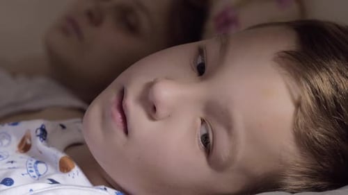 Child Lying on Pillow in Bed at Home