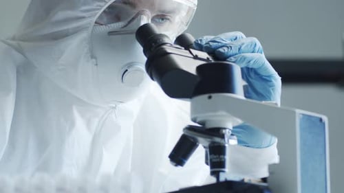 Scientist Inspects Sample Under Microscope in Laboratory