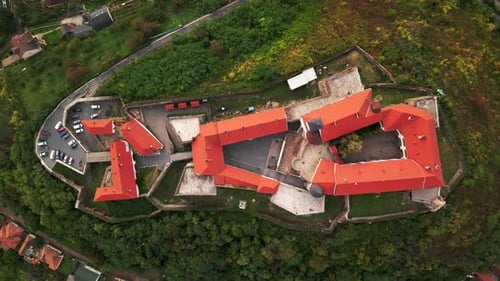 Aerial Top Down View of Medieval Castle on Mountain in Small European City at Cloudy Autumn Day
