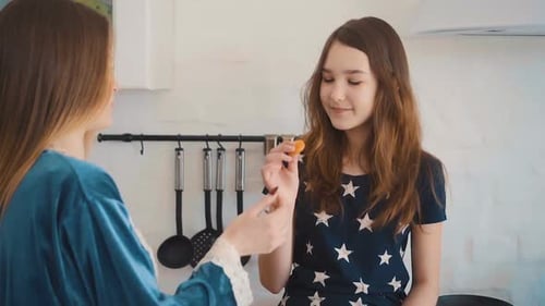 Females Eat Snack and Talk in Bright Kitchen