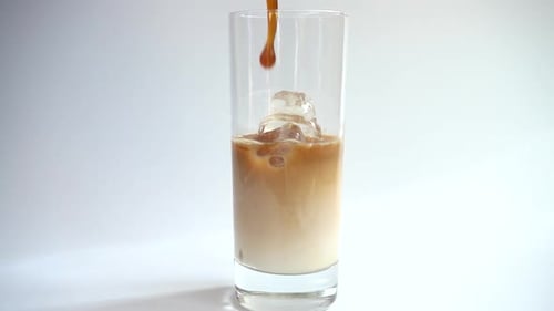 Pouring Coffee into Iced Drink on White