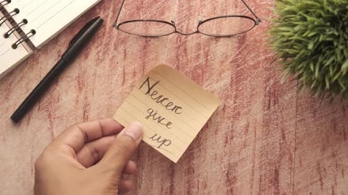 Mettre Never Give Up écrit sur un bloc-notes sur une table