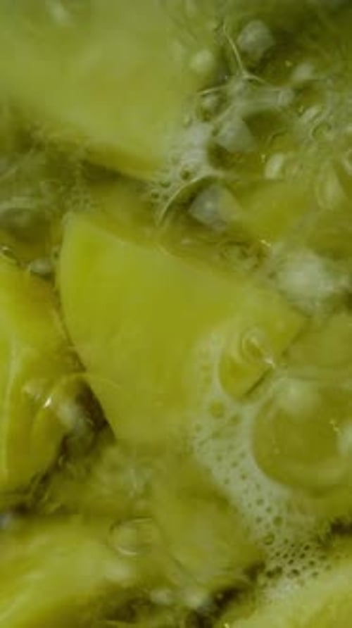 Grob gehackte Kartoffeln, die in heißem Wasser in einem Metalltopf zum Kochen von Kartoffelpüree kochen