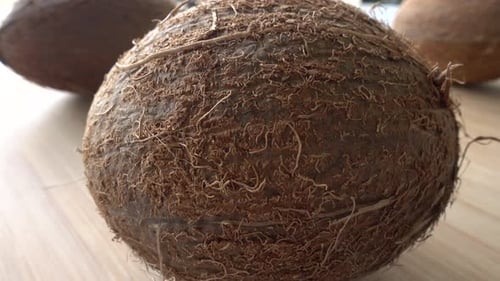 Close Up of Whole Coconuts on Wood Surface