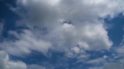 Fluffy Cumulus Clouds Drifting Across Blue Sky