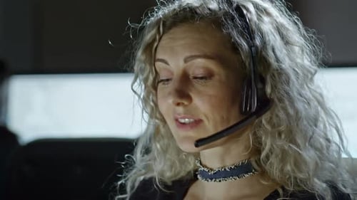 Woman with Headset Working at Computer in Office