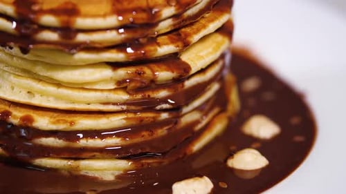 Pancakes Stacked High with Chocolate Sauce and Hazelnuts