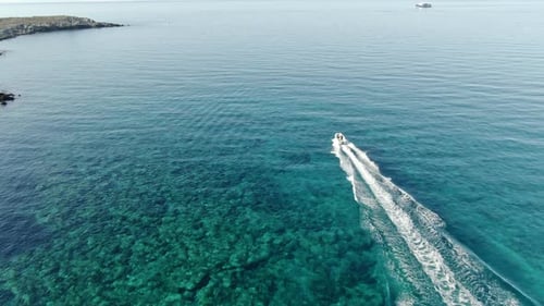 Coastal Motorboat Cruising on Turquoise Ocean Waters