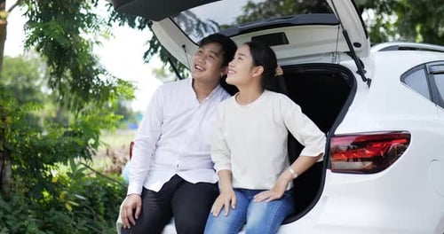Portrait of Happy Asian couple sit and look view in the back of a car