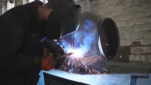 Welder Welding Metal Construction at Industrial Metalworking Production