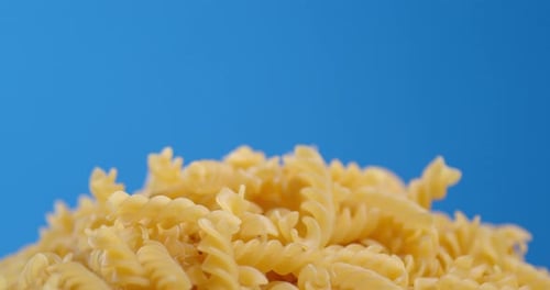 A Bunch of Dry Fusilli Pasta Rotates Slowly.