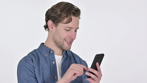 Young Man Using a Mobile Phone and Smiling