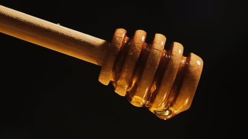 Close-up of Dripping Honey on Wooden Dipper