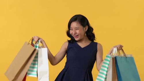 Woman Posing with Shopping Bags on Yellow Background