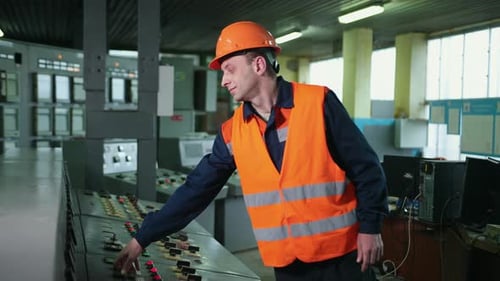 Man Operates Control Panel in an Industrial Setting