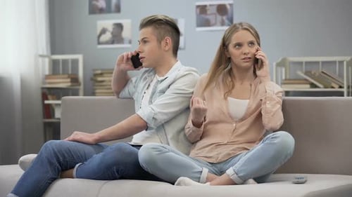 Student Girl and Boy Talking on Phones on Sofa, Imagining They Sitting Together
