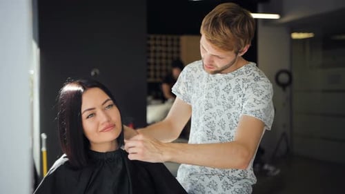 Hairstylist Cutting Woman's Hair in Modern Salon