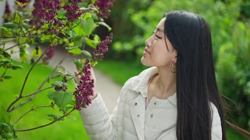 Happy Asian Young Woman Smelling Blooming Tree in Sunny Summer Spring Garden Outdoors Smiling