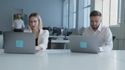 Deux employés de bureau font de leur mieux dans un travail en ligne