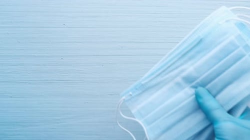 Medical Masks and Sanitizer on Blue Background