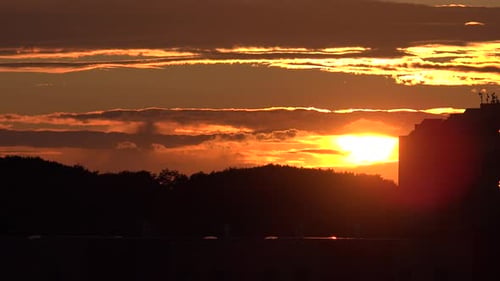 Zeitraffer des Sonnenuntergangs über Bäumen und Gebäuden
