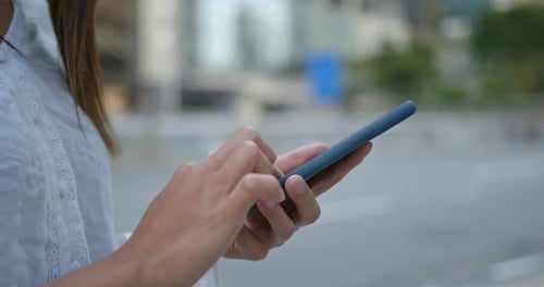 Hands Using Smartphone in Urban Setting