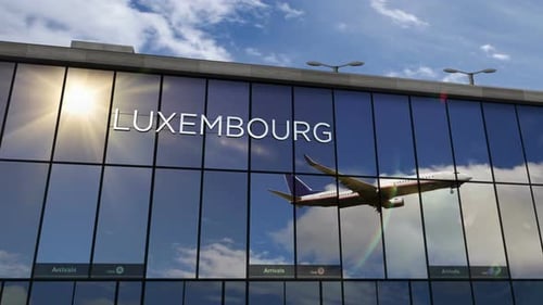 Avión que aterriza en el aeropuerto de Luxemburgo reflejado en la terminal