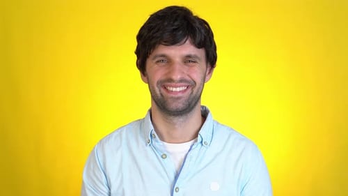 Smiling Man Poses Against a Yellow Background