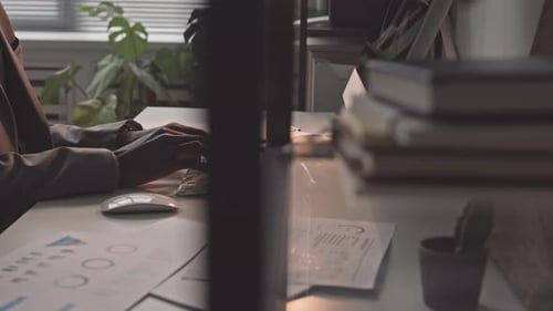 Person Typing on Keyboard in a Bright Office