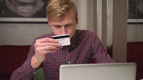 Young Adult Uses Credit Card with Laptop
