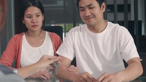 Happy Couple Receiving Keys in Modern Home