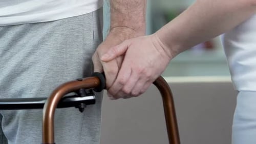 Man Trying to Walk with Frame, Wife Supporting Recovering Husband, Love and Care