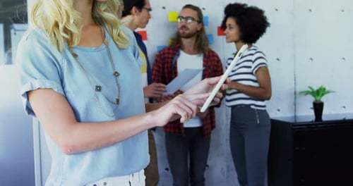 Woman Uses Tablet with Colleagues in Modern Office