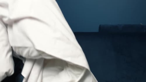 Man Sleeping Soundly on Blue Couch with Blanket