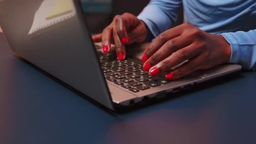 Nahaufnahme einer schwarzen Frau, die auf der Tastatur des Laptops tippt