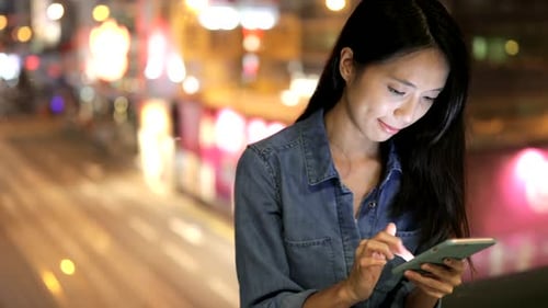 Woman using cellphone at night