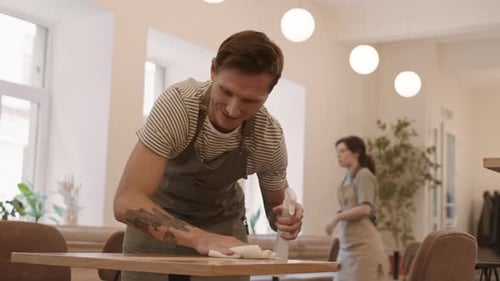 Male Cafe Worker Wiping Table