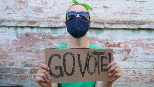 Woman shows cardboard Go Vote sign Voting balloting polling Political choice elections voice 4K