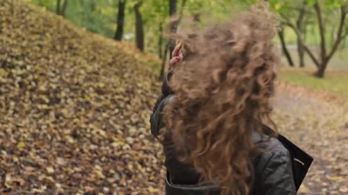Woman Walking in Autumn Park and Looking at Camera