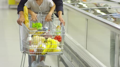Father and Daughter Pushing Shopping Cart