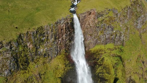 Aerial Drone Footage of Bjarnarfoss Waterfall Mountain Cliffs and Green Plateau in Western Iceland