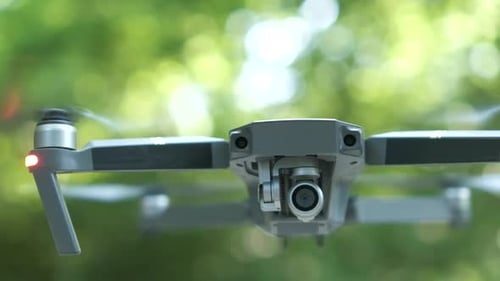 Drone Copter with Blurred Propellers and Video Camera Flying in Air