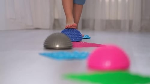 Child Walking Barefoot on Sensory Mat Path