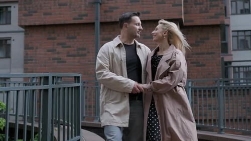 Happy Young Couple Holding Hands, a Guy and a Girl Are Hugging Along the City Street.