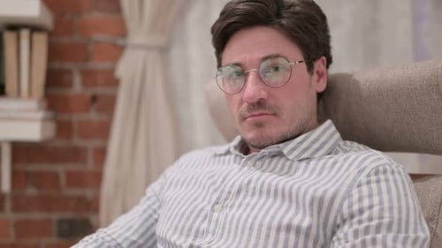 Man in Glasses Gesturing 'No' Indoors