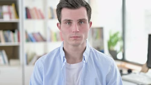 Lächelnder junger Mann, Student blickt in die Kamera