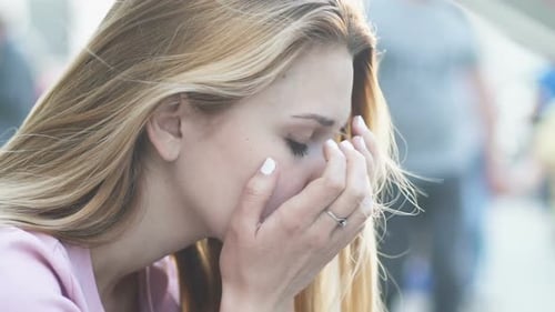 Mujer triste sentada en la calle cansada del ritmo diario, la vida estresante en Megalopolis