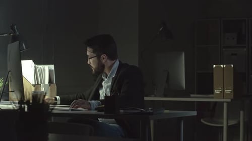 Homme travaillant dans le bureau la nuit