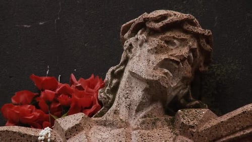 Stone Religious Statue With Red Roses and Beads
